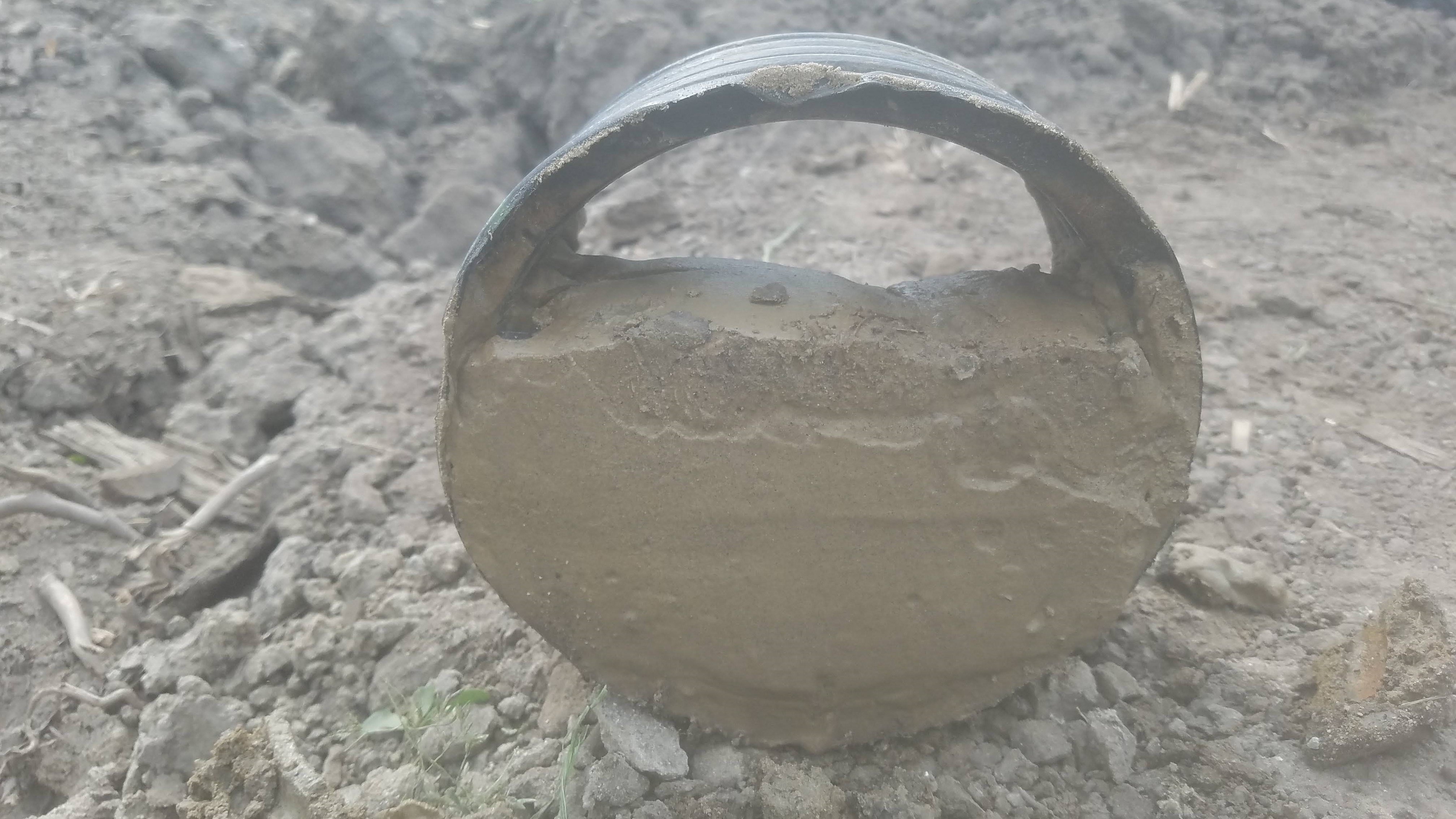 Photos of a 6-inch main installed in 2013 and was 2/3 filled with sand in 2020. The use of regular- perforated drains in sandy loam soil was the cause of drain sedimentation 